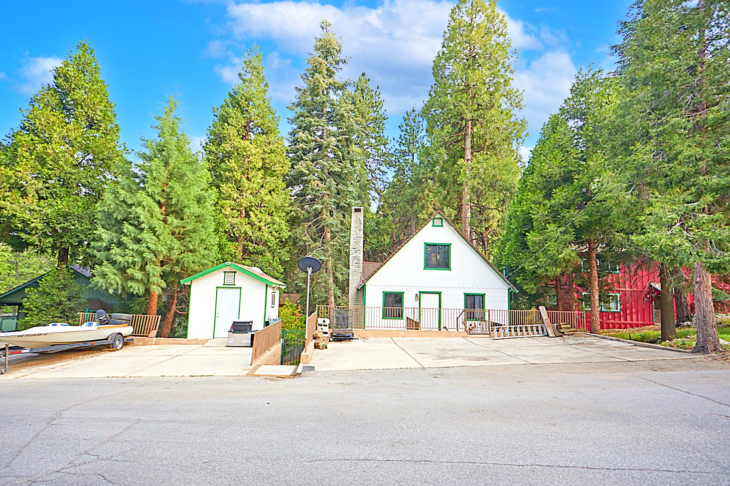 A white A frame cabin among tall pines